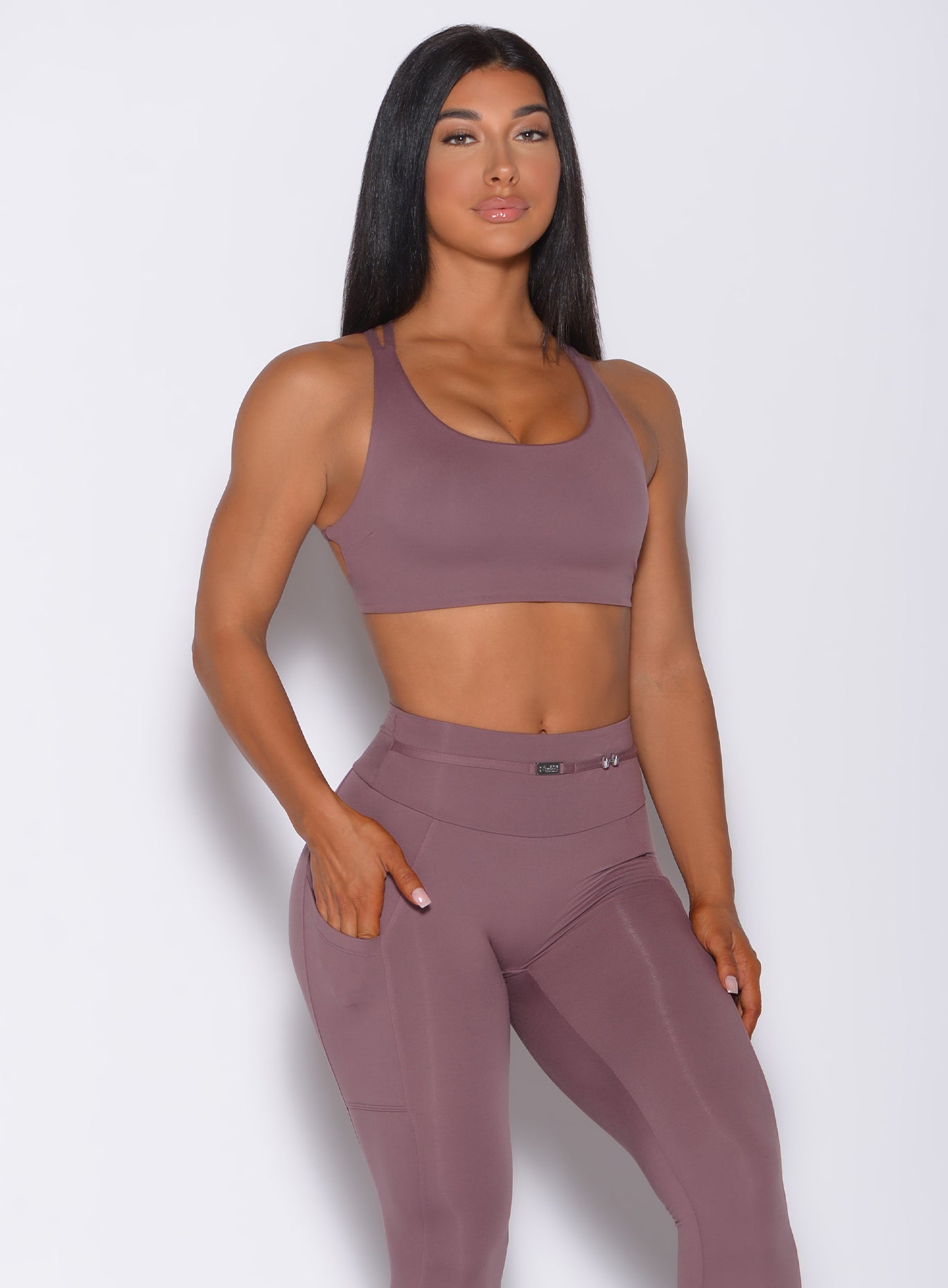 Front profile view of a model wearing our mauve barbell sports bra and a matching leggings
