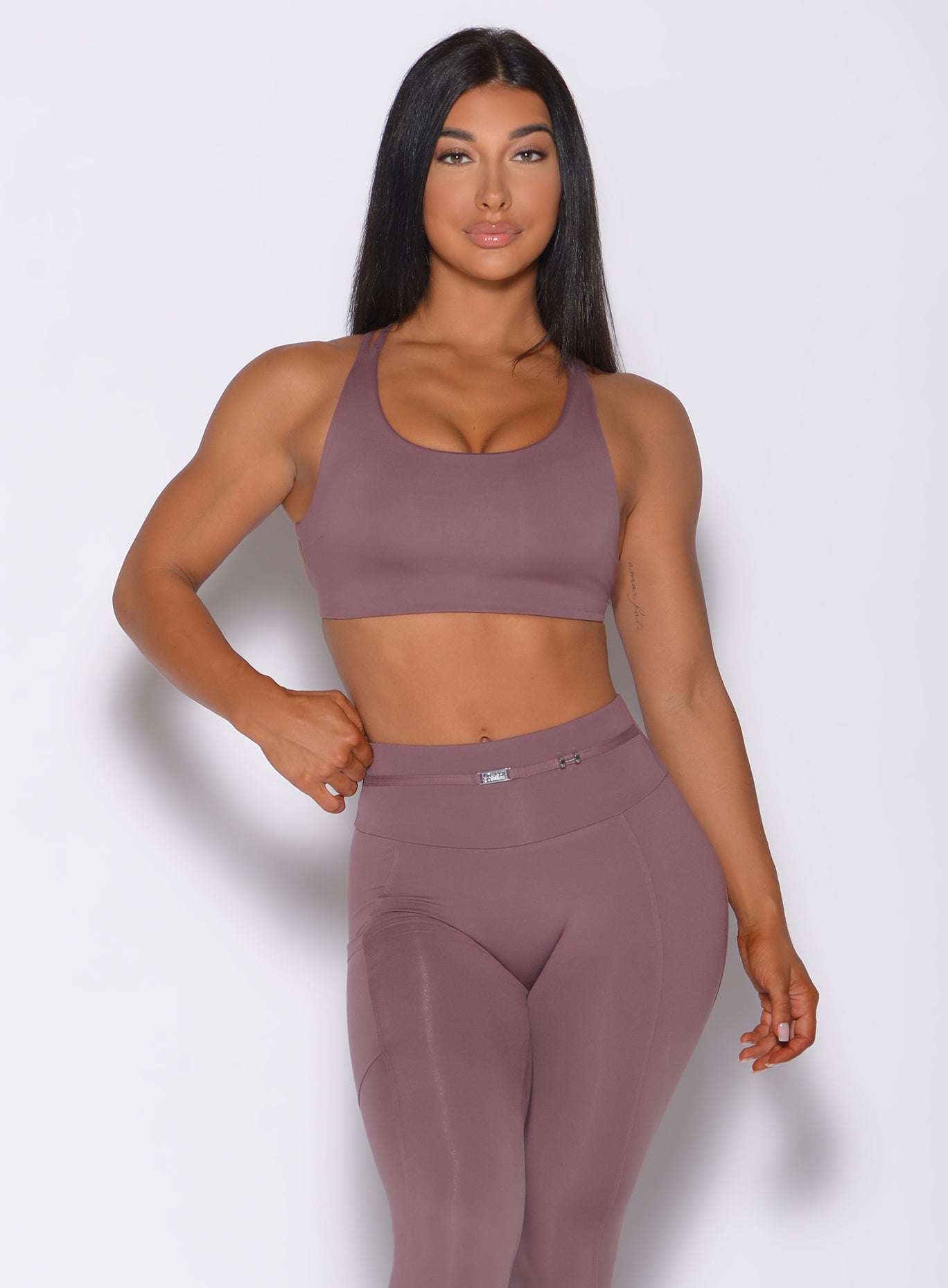 Front profile view of a model in our mauve barbell sports bra and a matching leggings