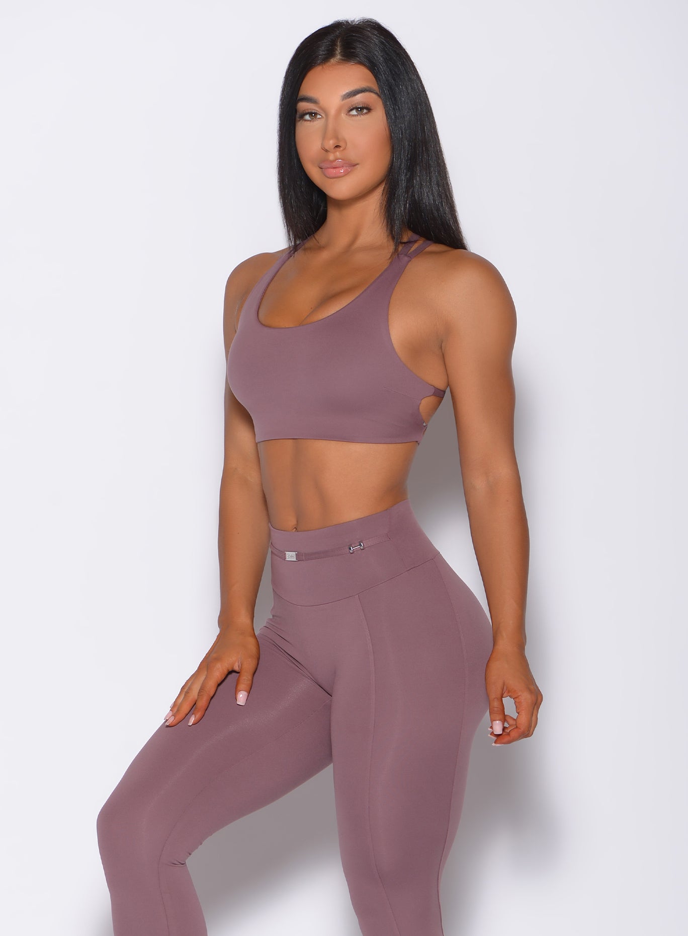 Left side profile view of a model angled left wearing our mauve barbell sports bra and a matching leggings