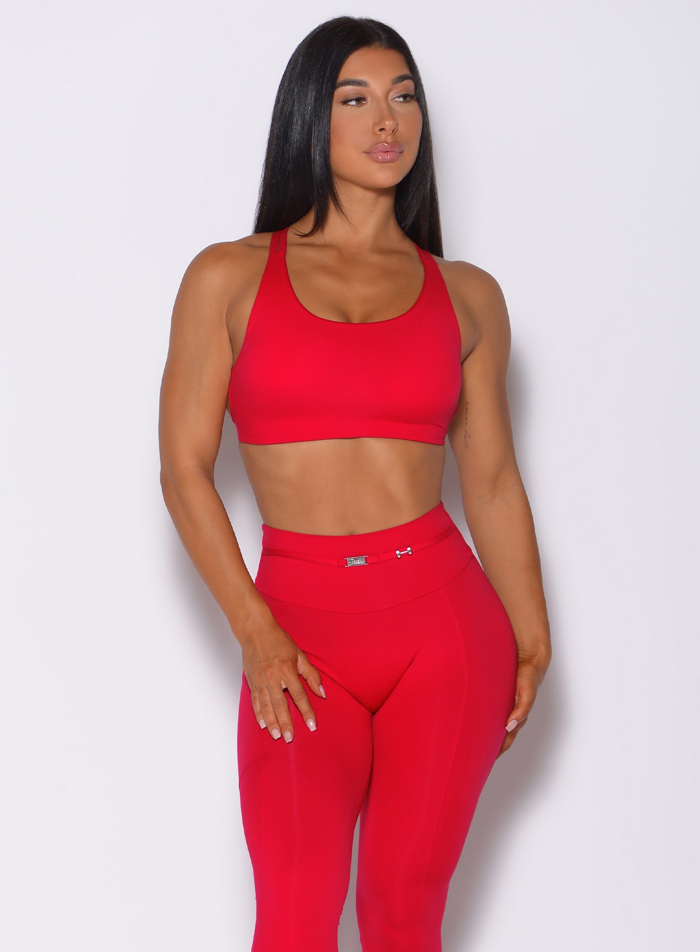 Front profile view of a model in our red barbell sports bra and a matching leggings