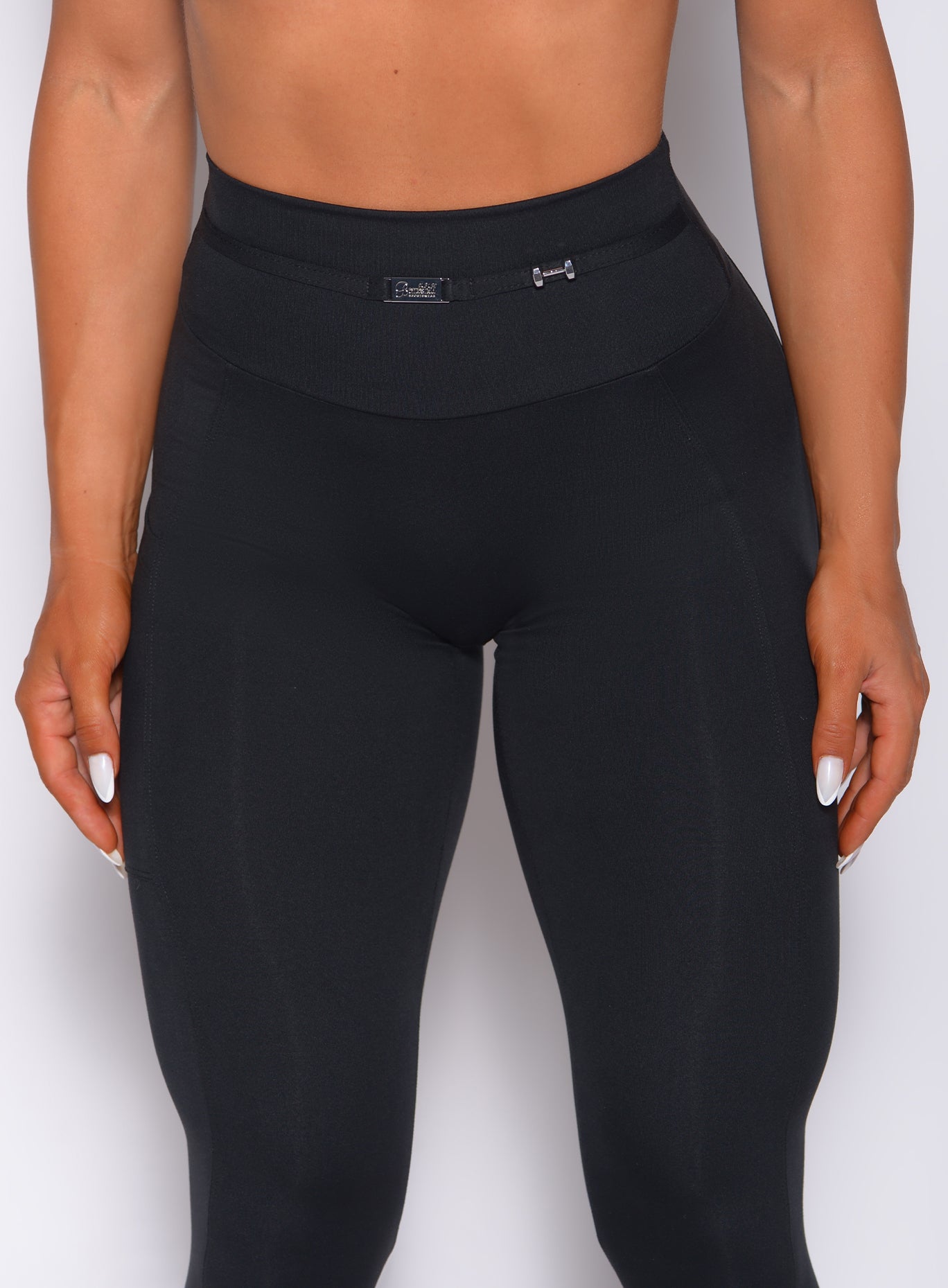 Zoomed in front profile view of a model wearing our black barbell leggings 