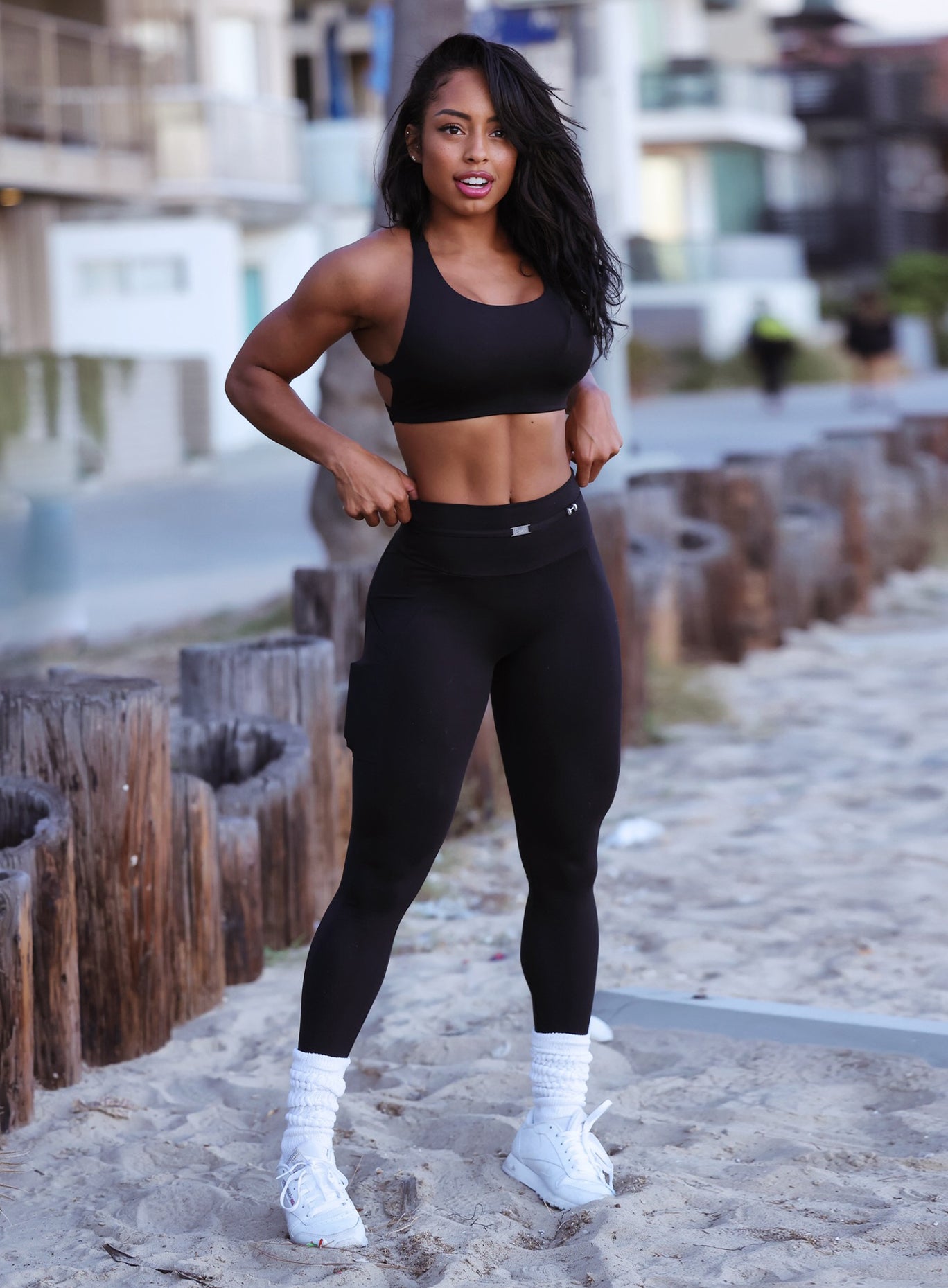 Front profile view of a model in our black barbell leggings and a matching bra 