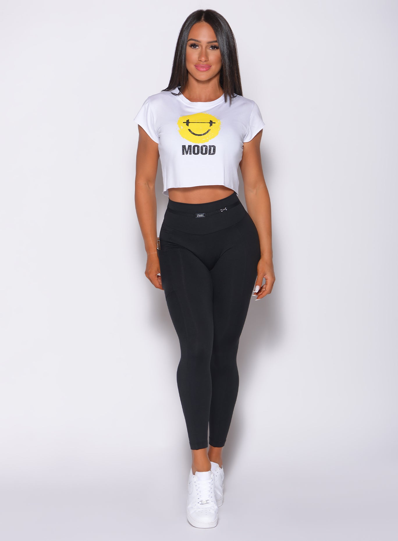 Model facing forward wearing our white mood tee and a high waisted black leggings 
