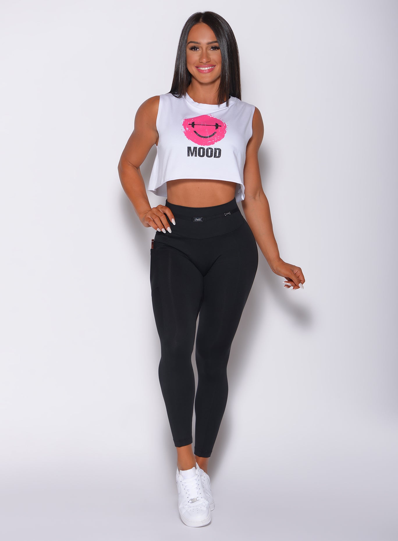 Model facing forward wearing our white mood tank and a black high waist leggings 