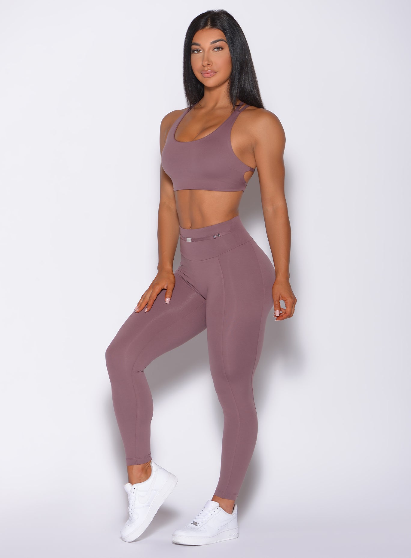 Front profile view of a model facing forward wearing our barbell legging in mauve color and a matching bra