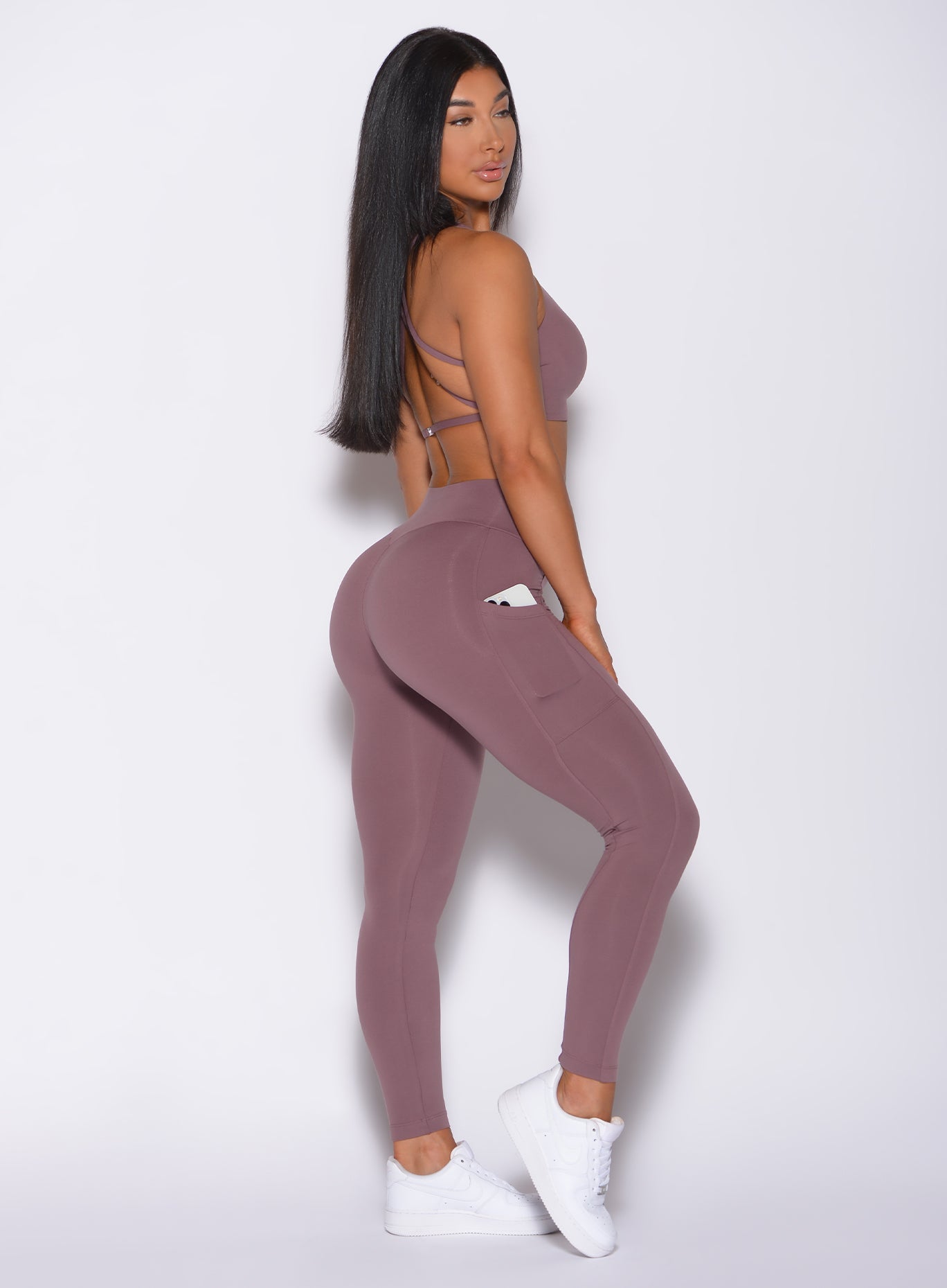 Right side profile view of a model in our barbell legging in mauve color and a matching bra