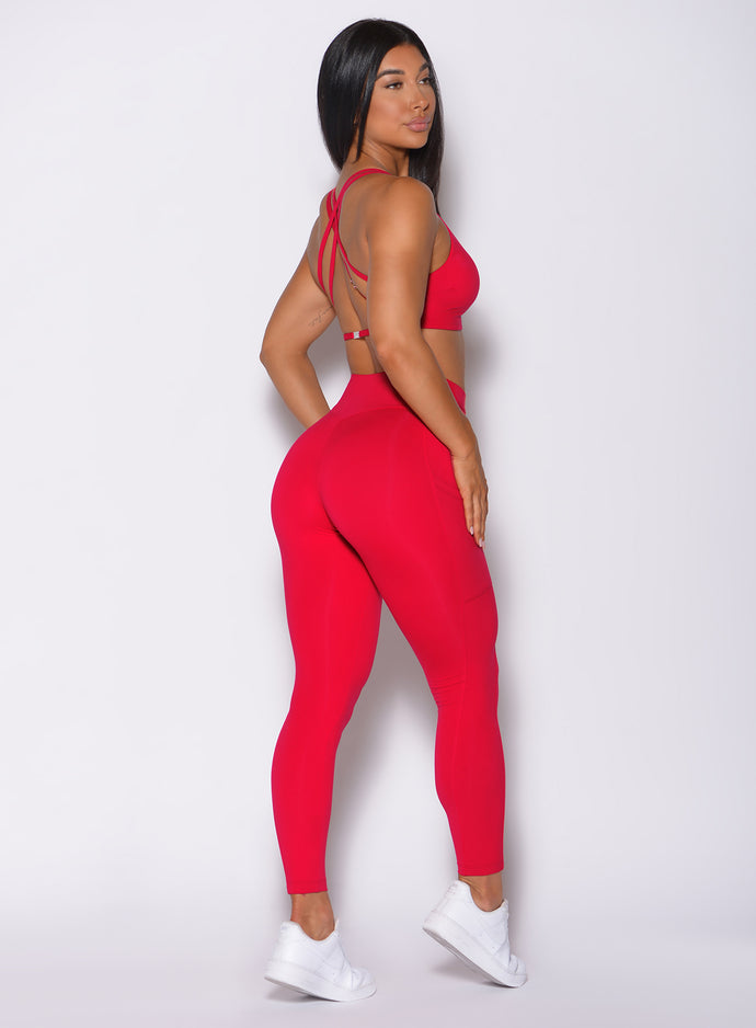 Right side profile view of a model in our red barbell leggings and a matching bra 