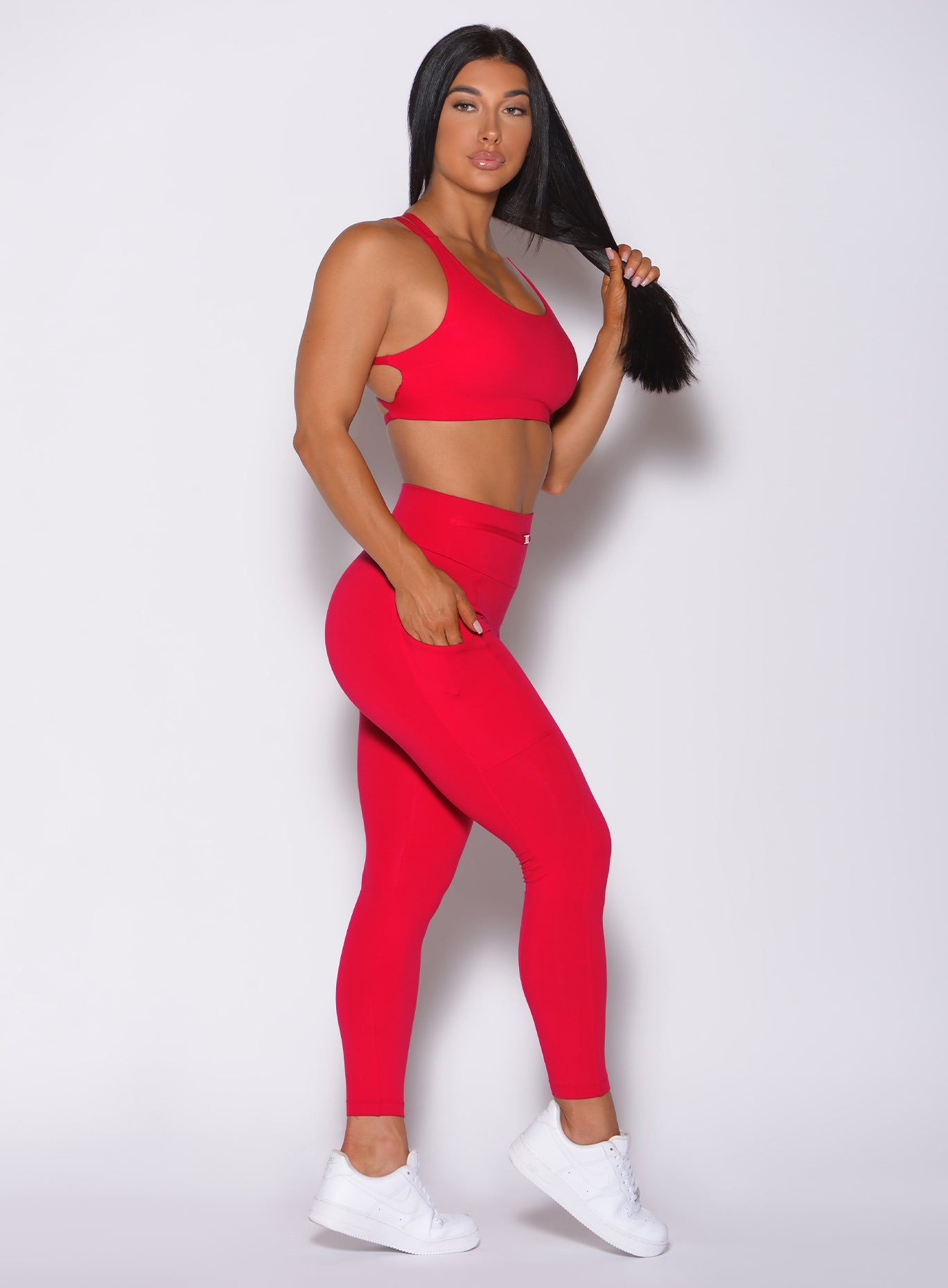 Right side profile view of a model wearing our red barbell leggings and a matching bra