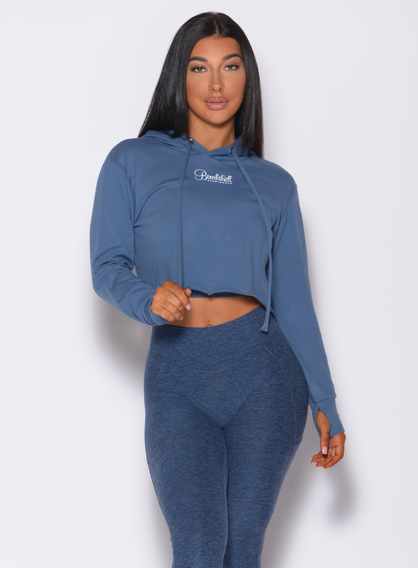 Front  profile view of a model in our bombshell hoodie in blue star color and a matching leggings
