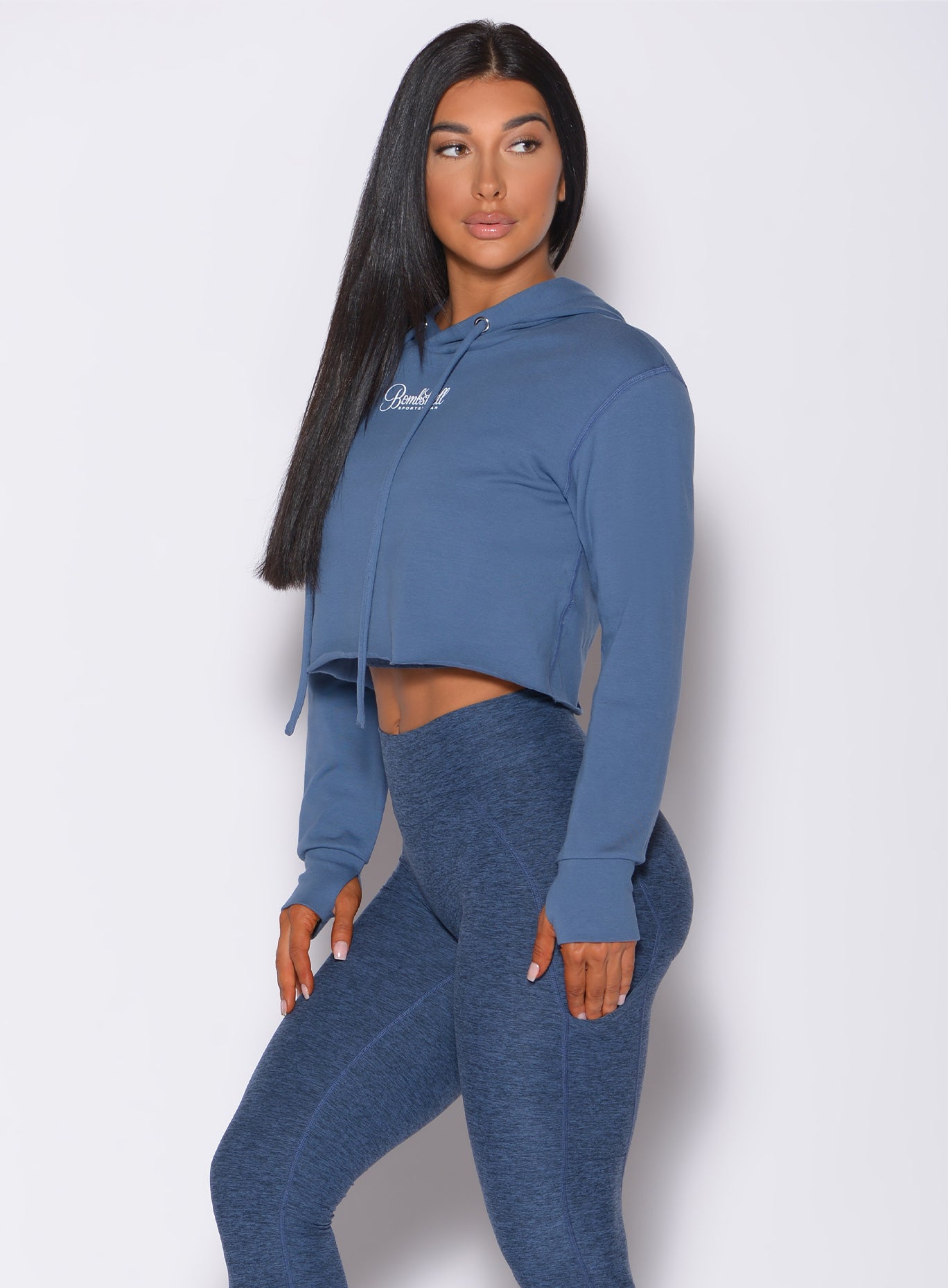 Left side profile view of a model in our bombshell hoodie in blue star color and a matching leggings