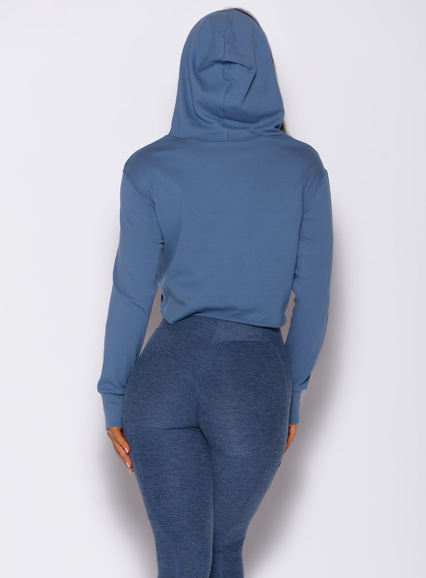 Back  profile view of a model wearing our bombshell hoodie in blue star color and a matching leggings