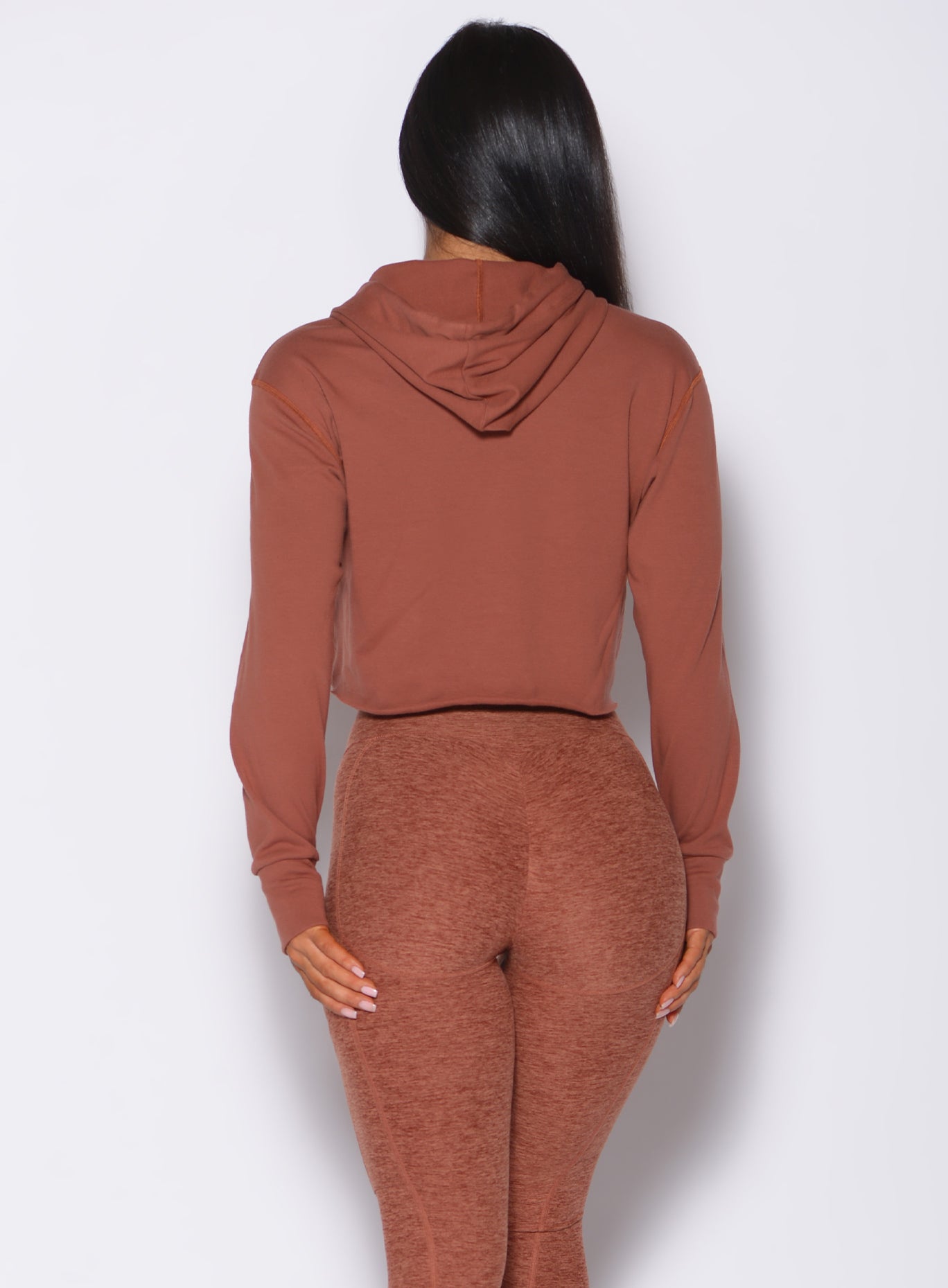 Back profile view of a model in our bombshell hoodie in caramel color and a matching leggings