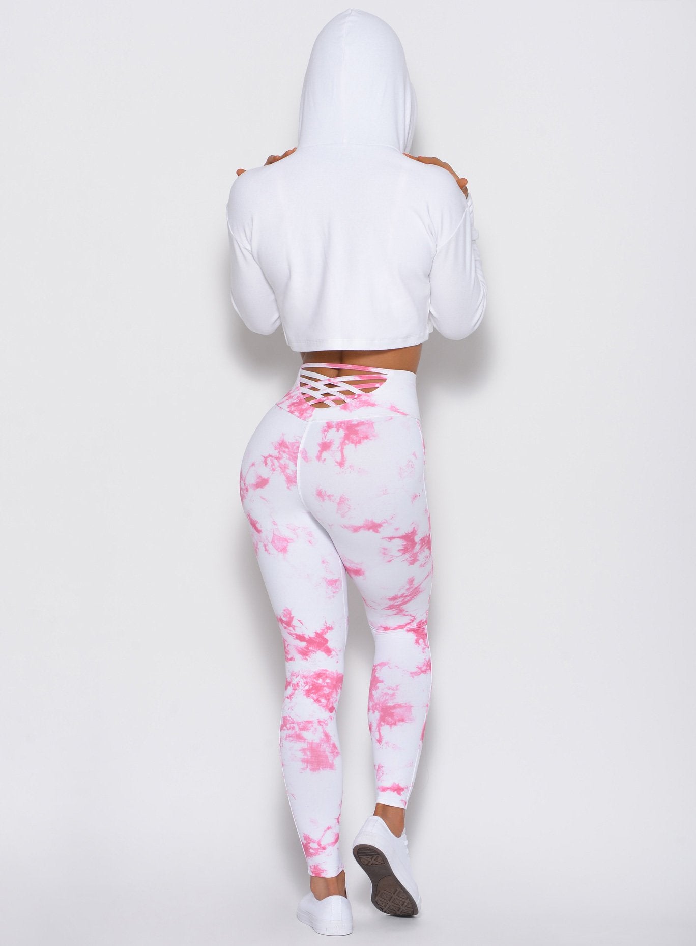 Back profile of the model wearing the Bombshell Crop Hoodie in white color
