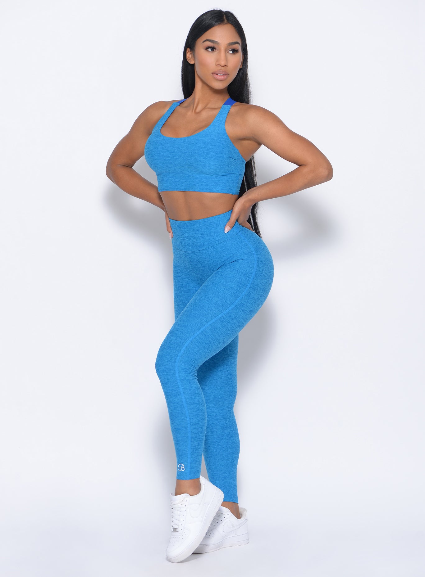 Front profile view of the model angled right in our elevated tank bra in sky blue and a matching leggings