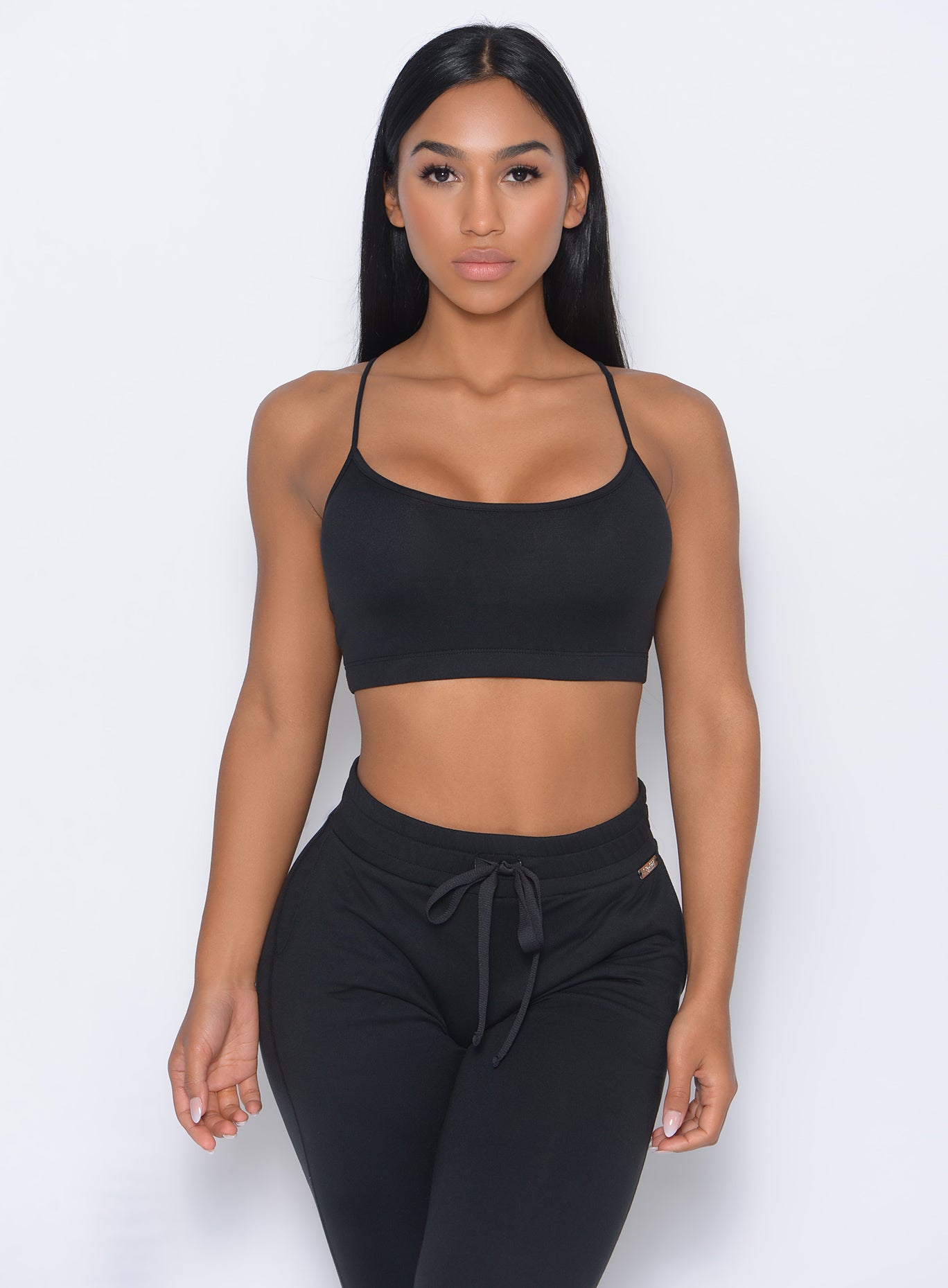 Front profile view of the model in our black Relax Sports Bra and a matching joggers