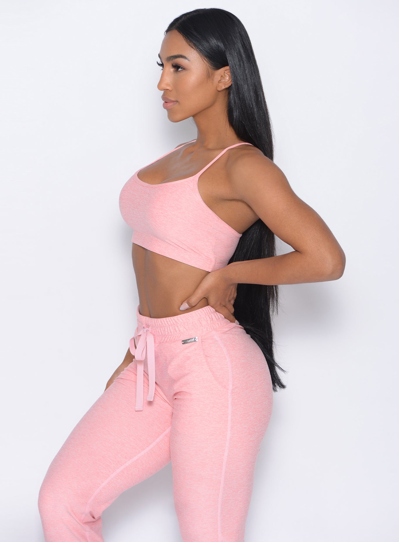 Left side view of the model wearing our relax sports bra in peach pink and a matching joggers