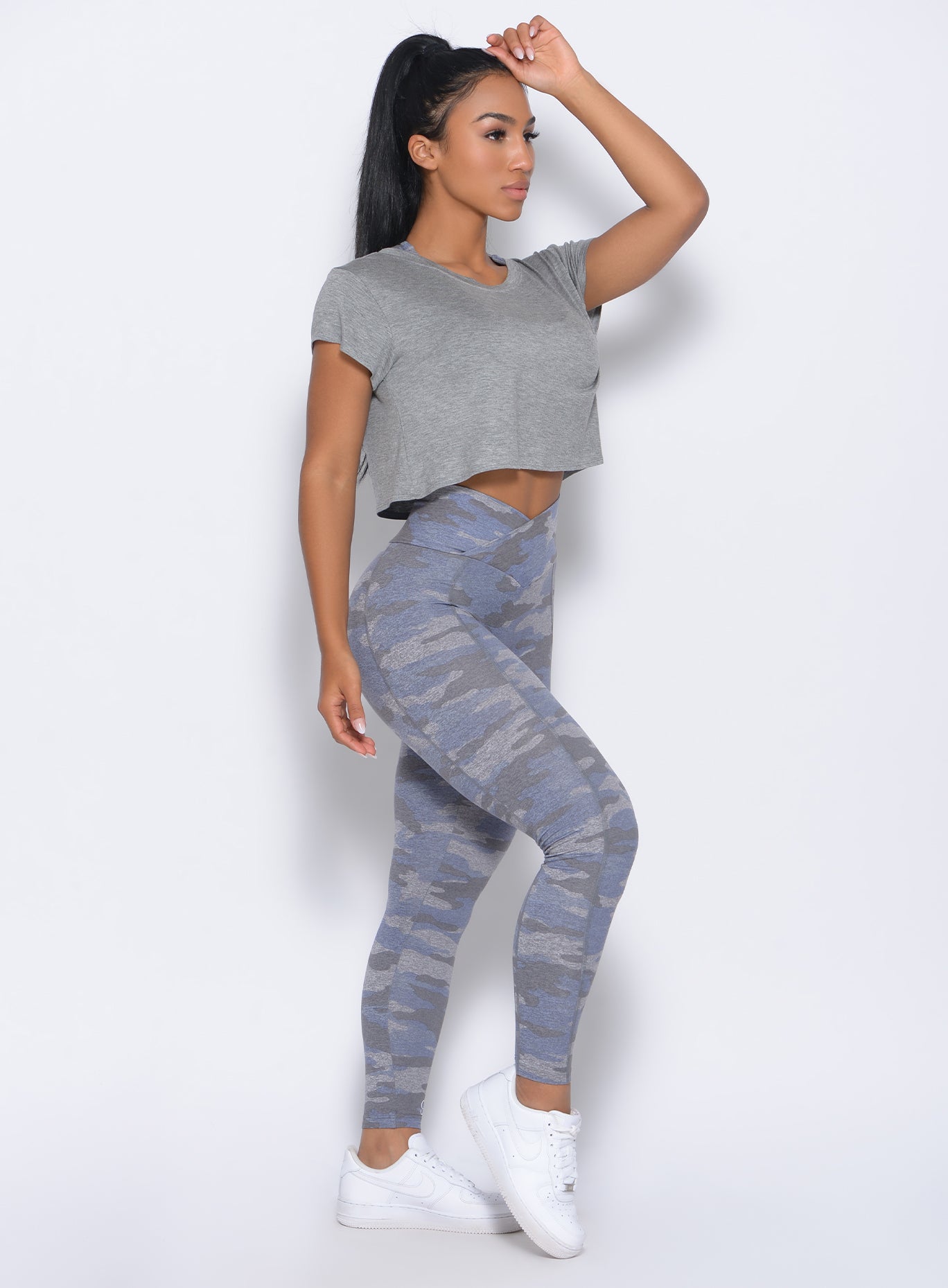 Right side view of the model in our freedom tee in silver color and a matching leggings