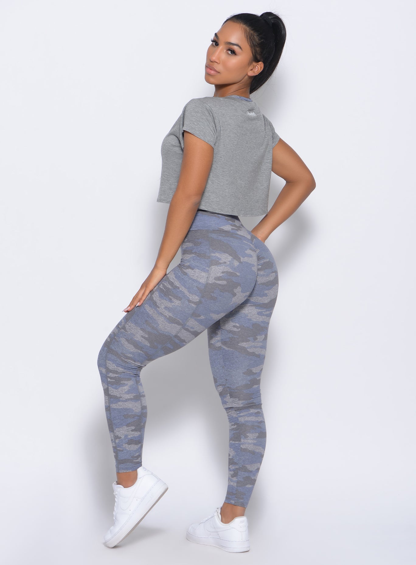 Left side view of the model wearing our brazilian contour leggings in silver camo and a matching bra