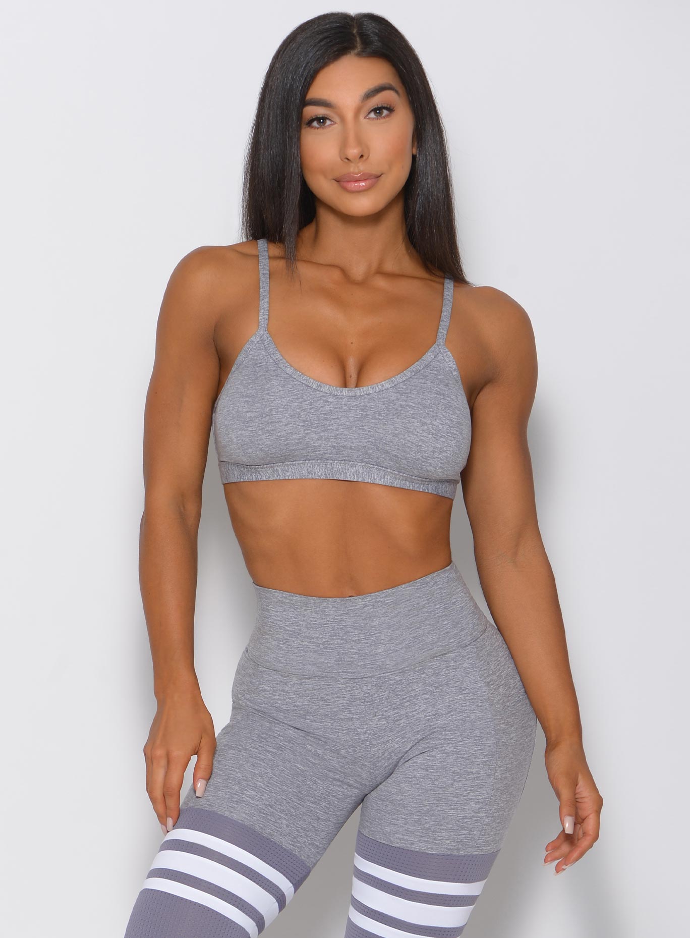 Model facing forward in grey sports bra and matching high waisted leggings