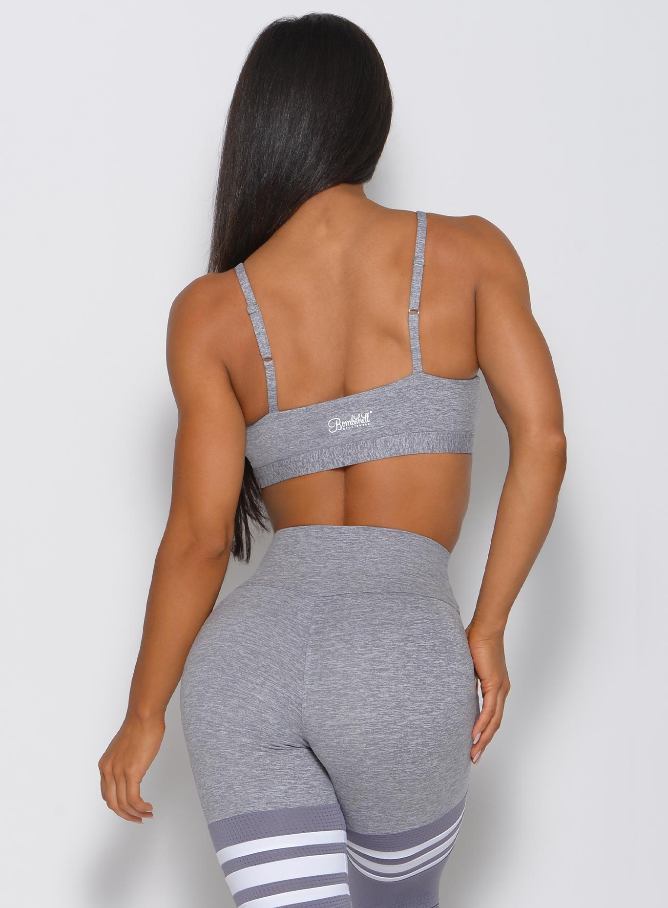 Back photo of model wearing grey sports bra and matching bottoms 
