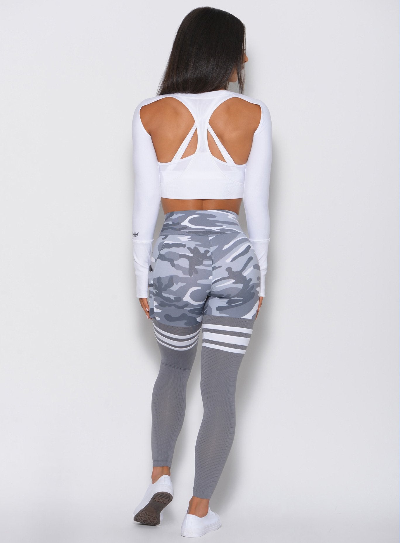 Back view of the model in the gray camo high waisted leggings with three white stripes on each side 