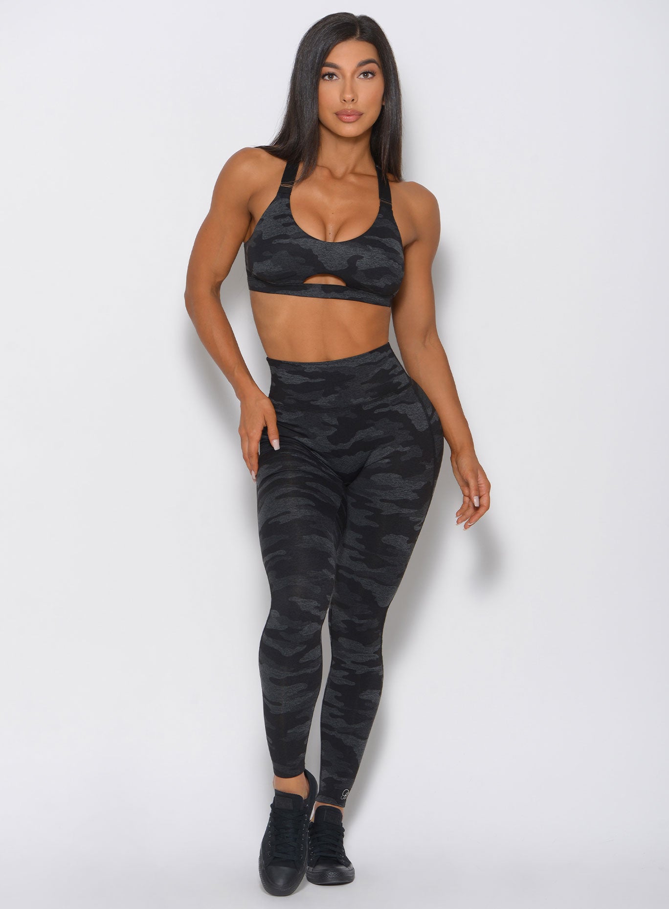 Front view of the model wearing the camo leggings in charcoal color with a matching bra 