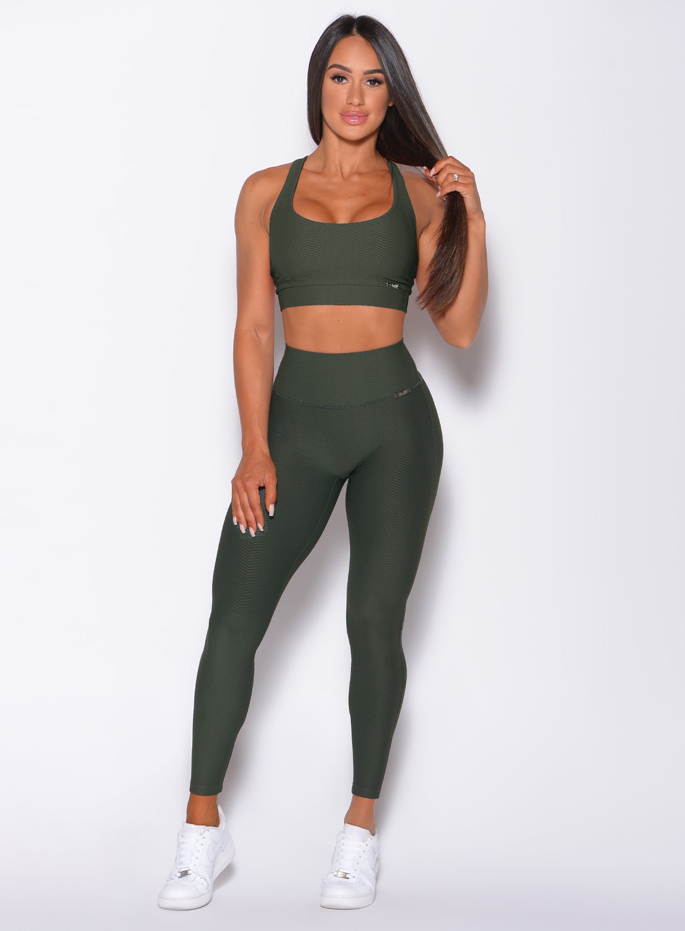 Model facing forward wearing our chevron leggings in lucky green color and a matching bra