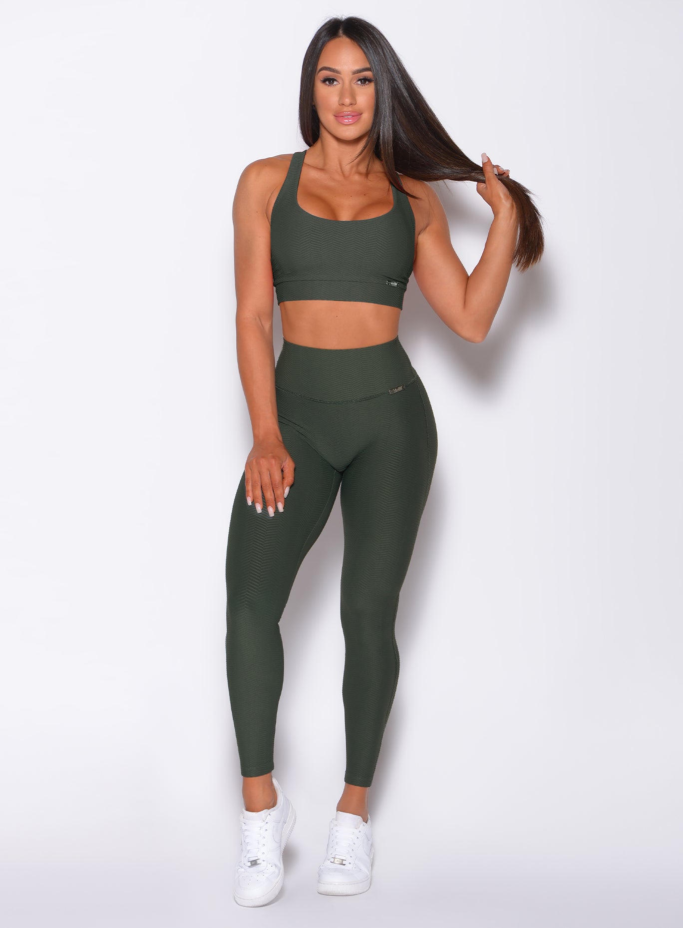 Front profile view of a model in our Chevron Leggings in lucky green color and matching bra
