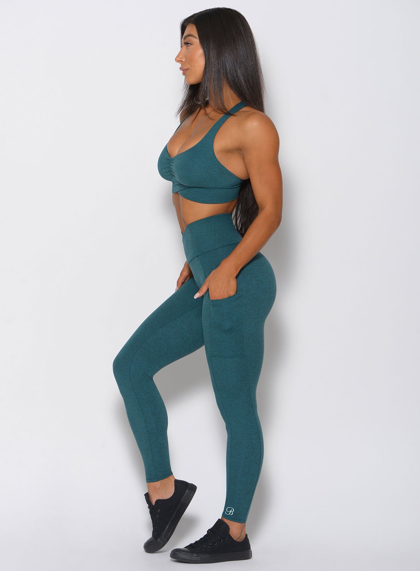 model in teal contour leggings facing left arms at side