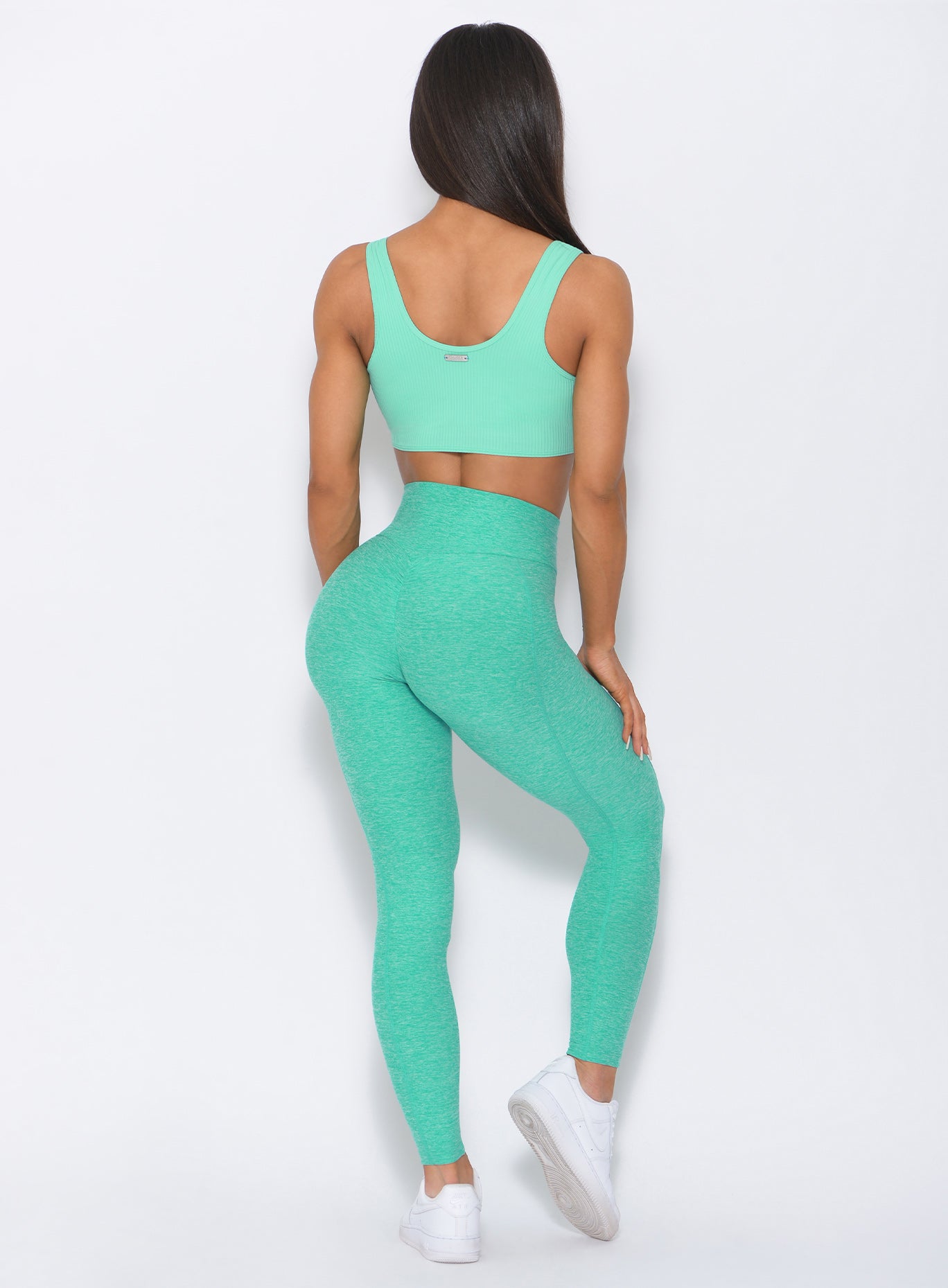 Back view of the model in our mint Brazilian contour leggings and a matching bra '