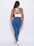 Back view of the model wearing our Brazilian contour leggings in ocean color and a white top