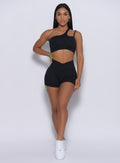 Model facing forward wearing our Contour Toggle Shorts in Black color and a matching sports bra