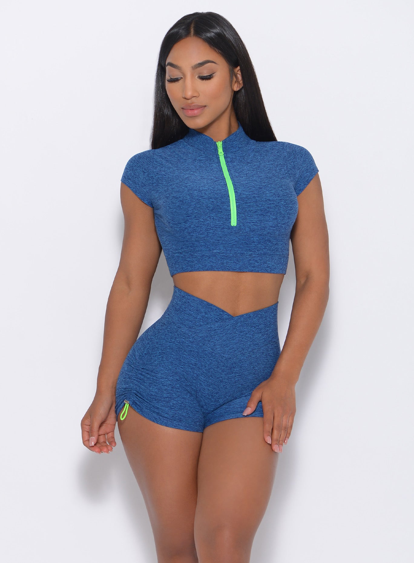 Front view of the model in our neon zip top in ocean color and a matching shorts