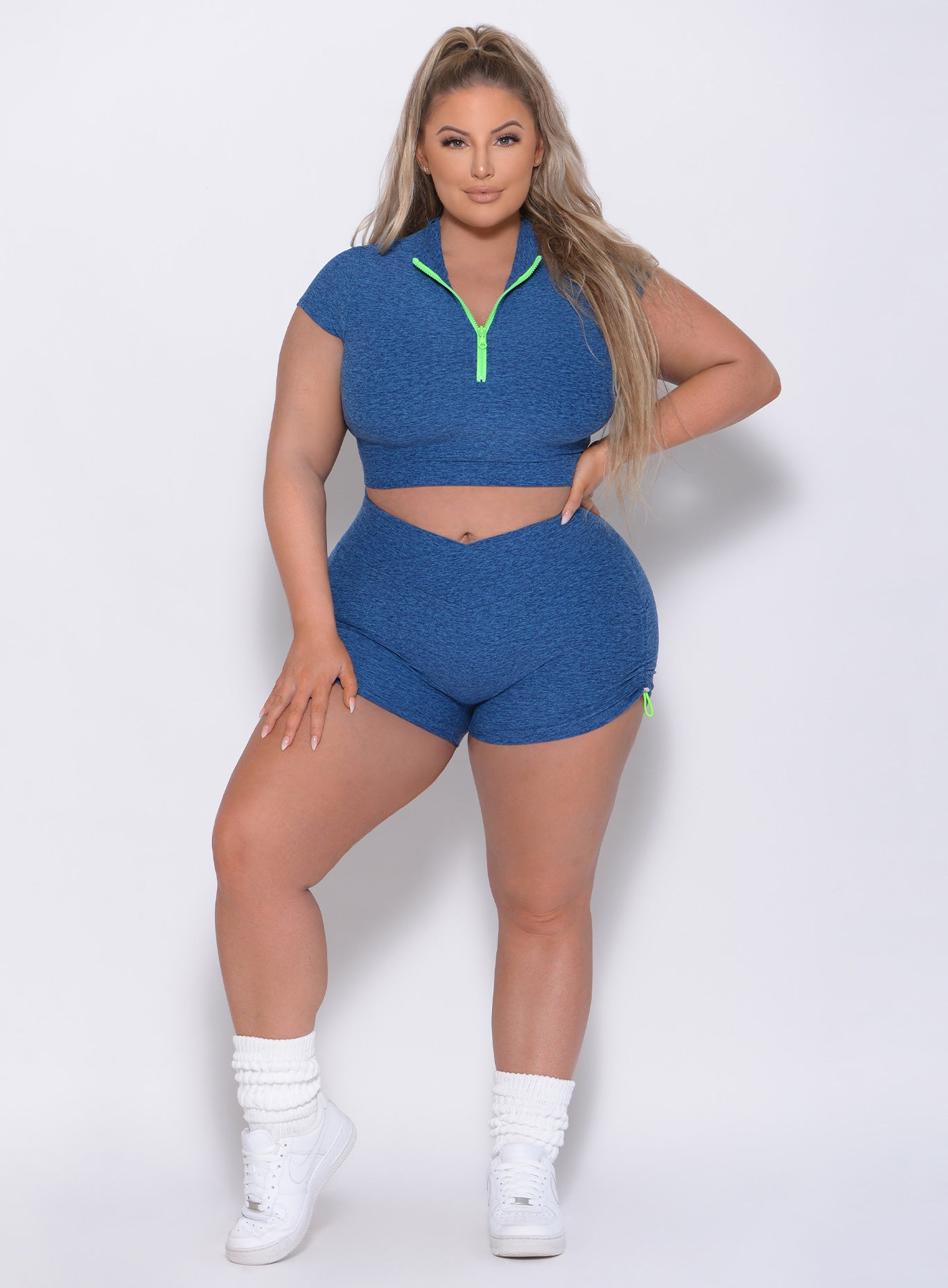 Front view of the model with her left hand on thigh wearing our contour shorts in ocean color and a matching top