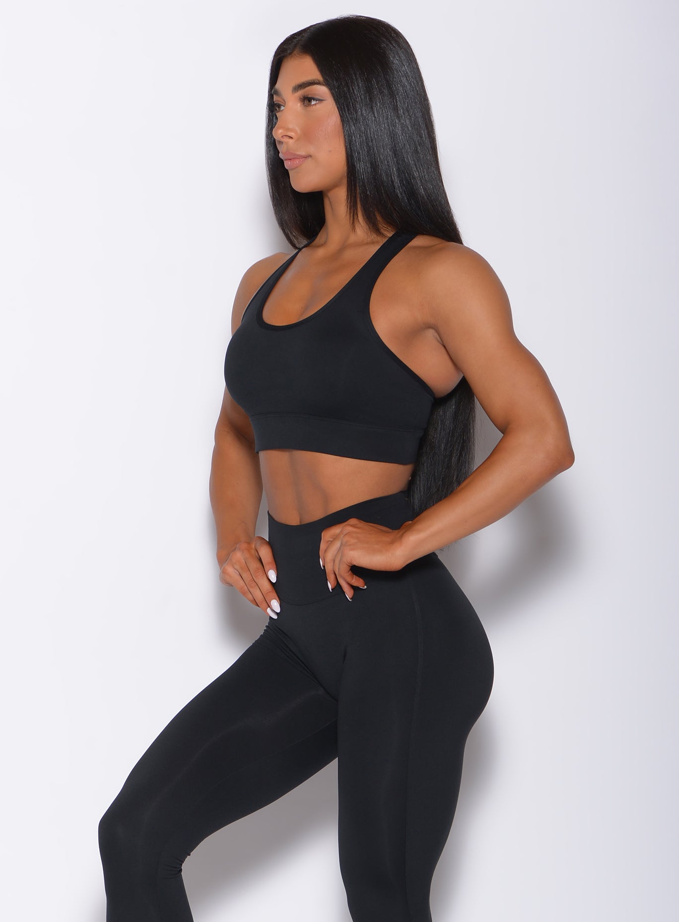Left side profile view of a model wearing our black rival sports bra and a matching leggings