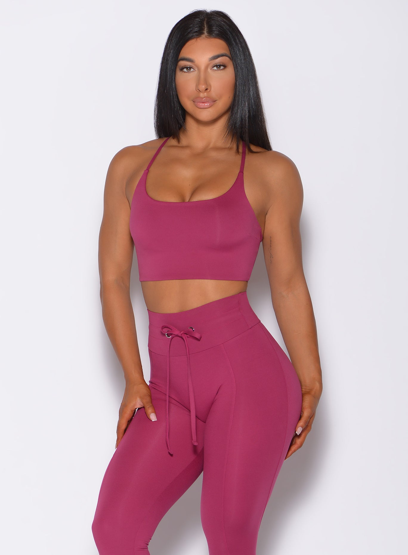 Model facing forward wearing our cross fit sports bra in berry good color and a matching leggings