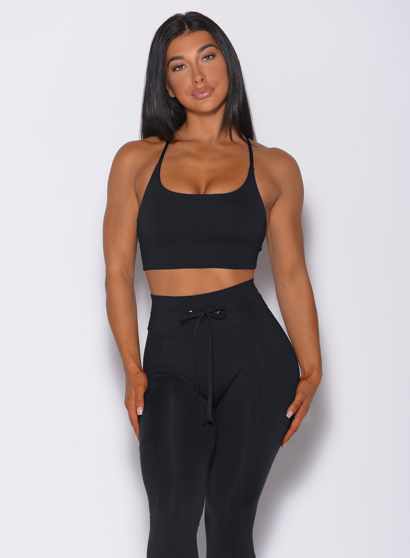 Front profile view of a model in our black Cross Fit Sports Bra and a matching leggings