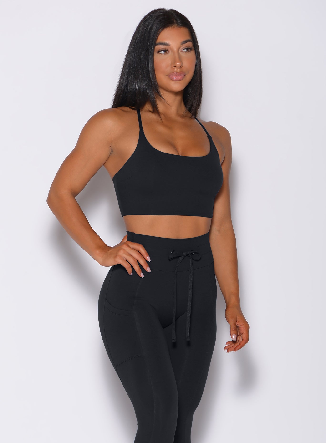 Front profile view of a model wearing our black Cross Fit Sports Bra and a matching leggings