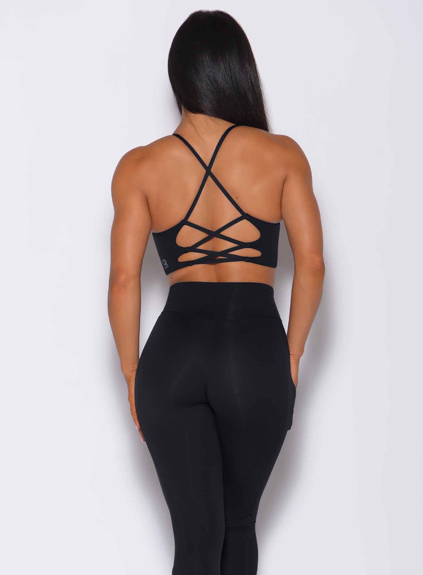 back profile view of a model in our black Cross Fit Sports Bra and a matching leggings 