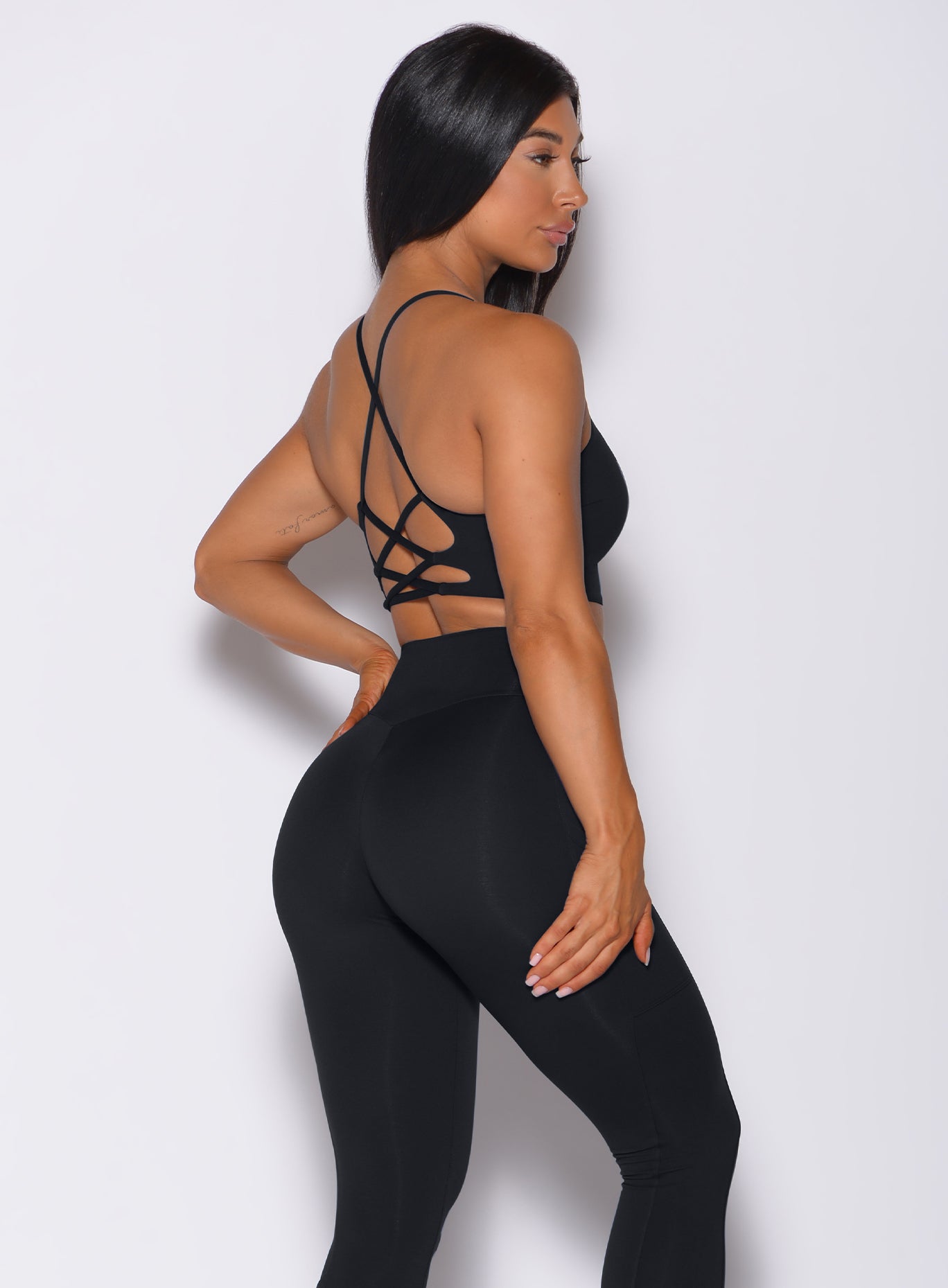Right side profile view of a model in our black Cross Fit Sports Bra and a matching leggings