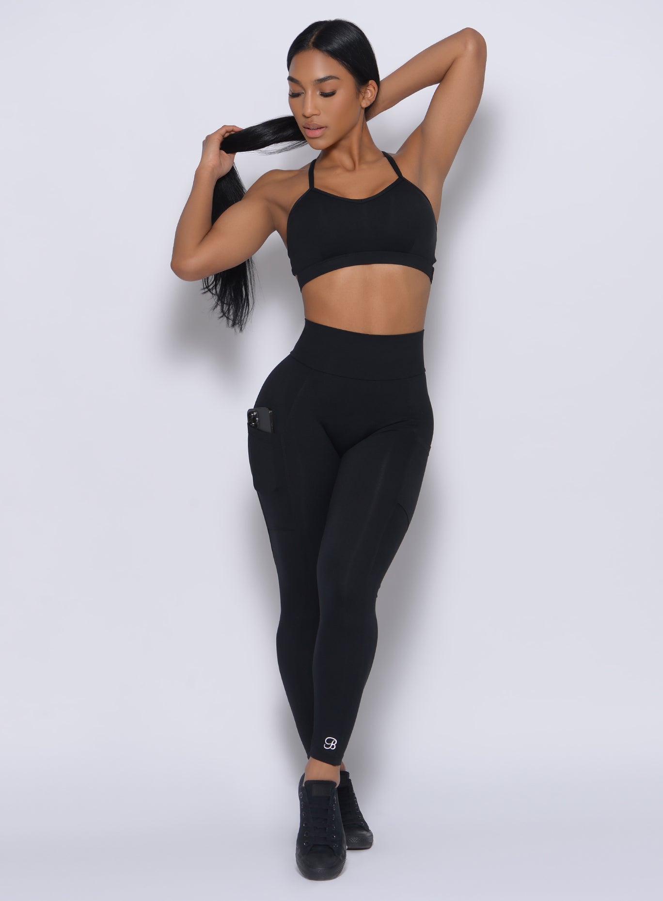 Front profile view of a model wearing our black pumped sports bra and a matching leggings