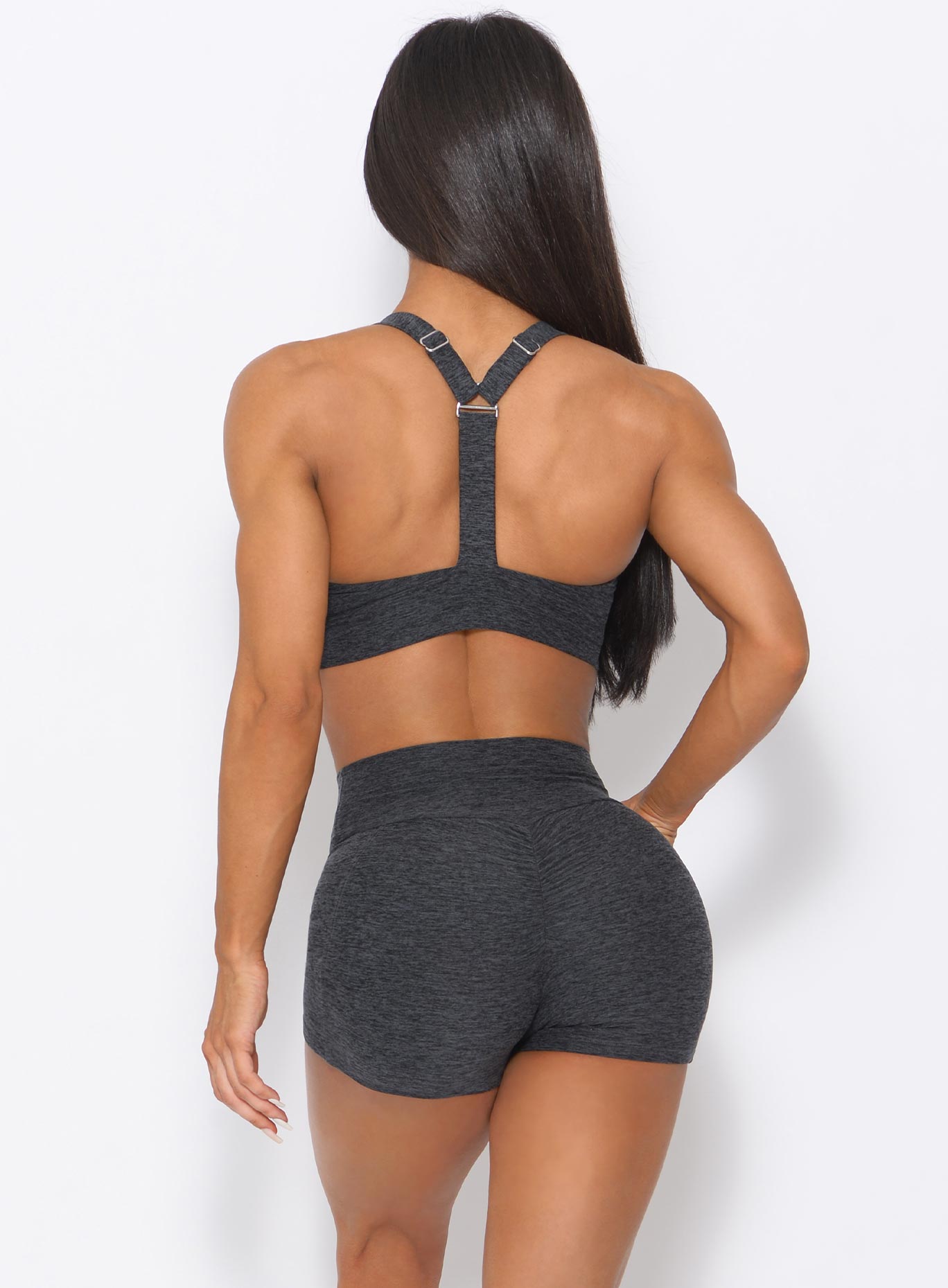 back view of the model wearing our curves high waist shorts in charcoal color and a matching bra