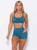Model facing forward wearing our perfection sports bra in seafoam color and a matching shorts 