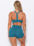 Back view of the model  wearing our perfection sports bra in seafoam color and a matching shorts