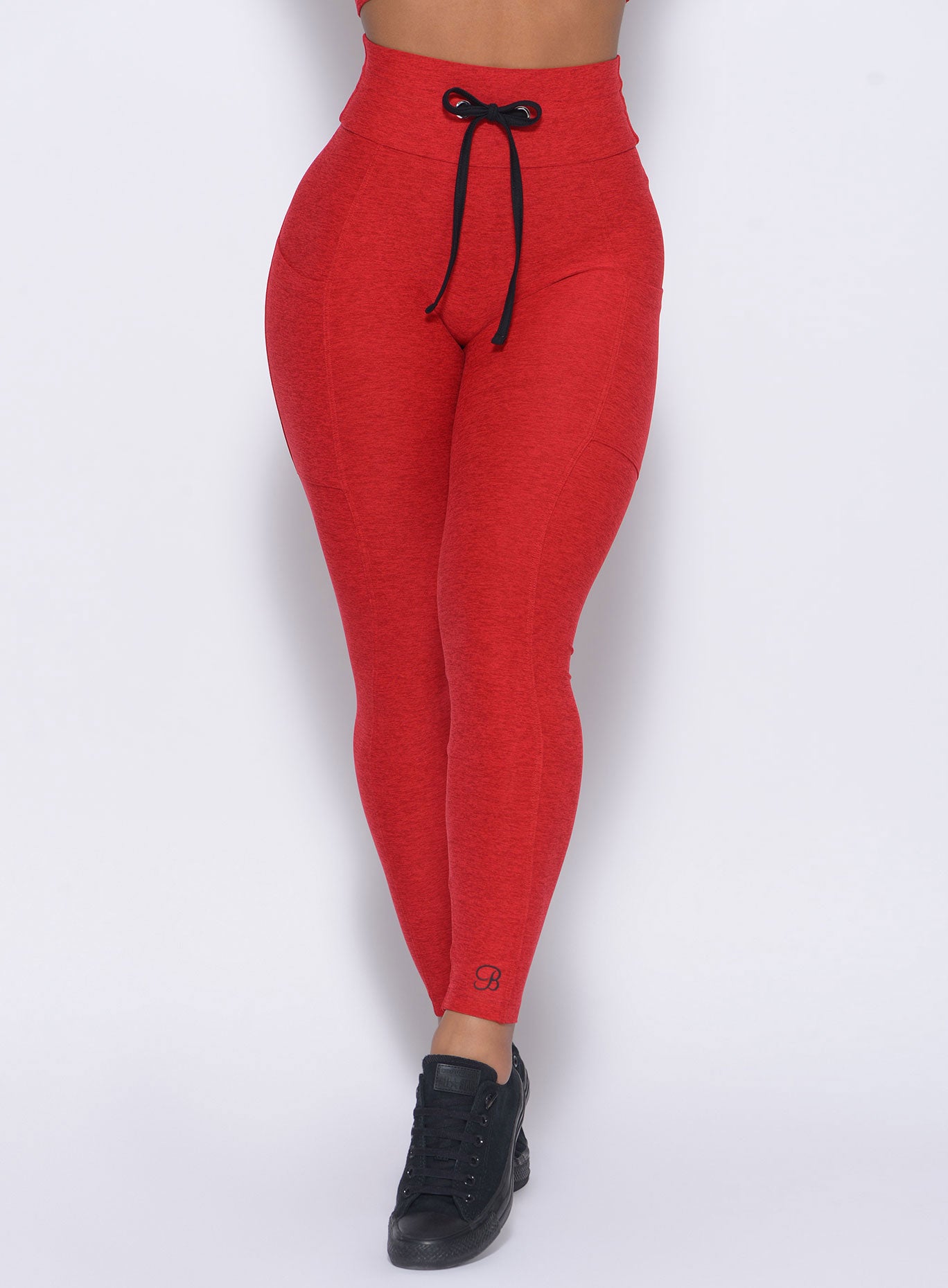Zoomed in front view of our Thrive Leggings in sunset red color 