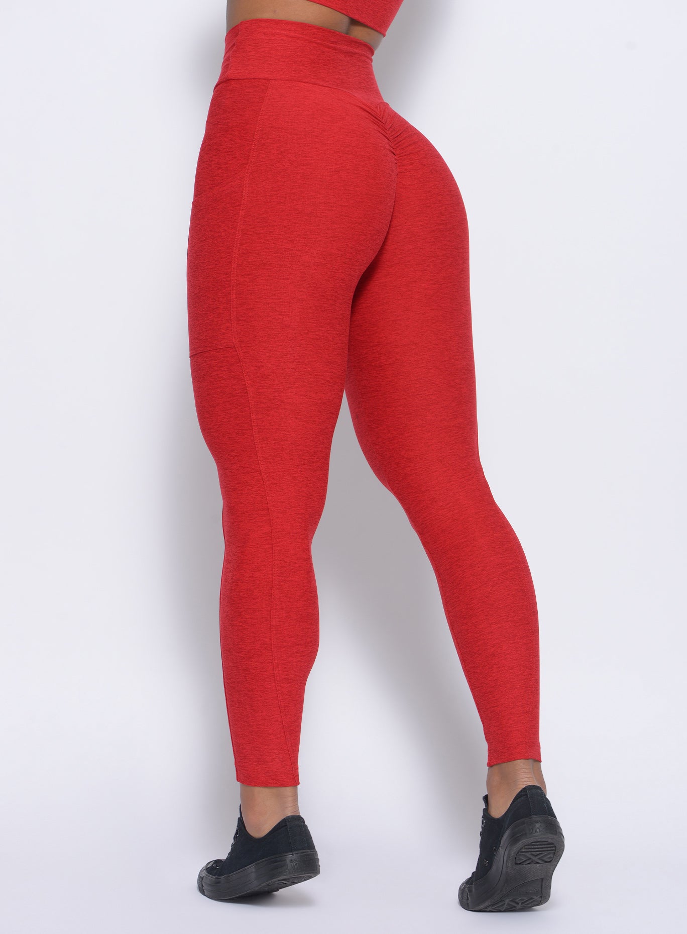 Zoomed in back view of our thrive leggings in sunset red color 