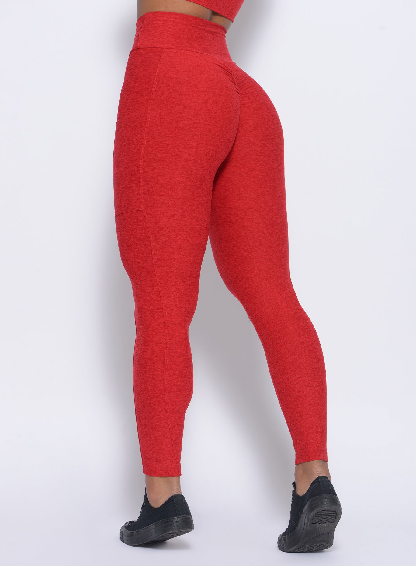 Zoomed in back view of our thrive leggings in sunset red color 