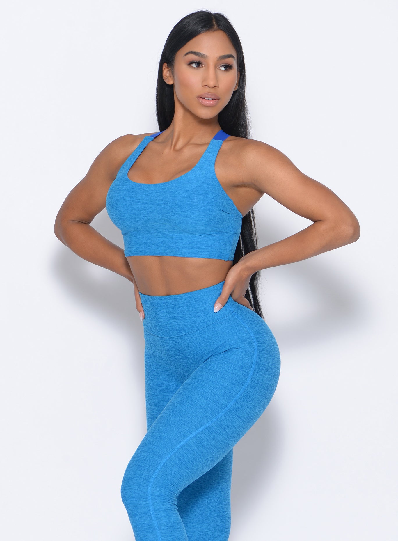 Left side view of the model angled left in our elevated tank bra in sky blue and a matching leggings