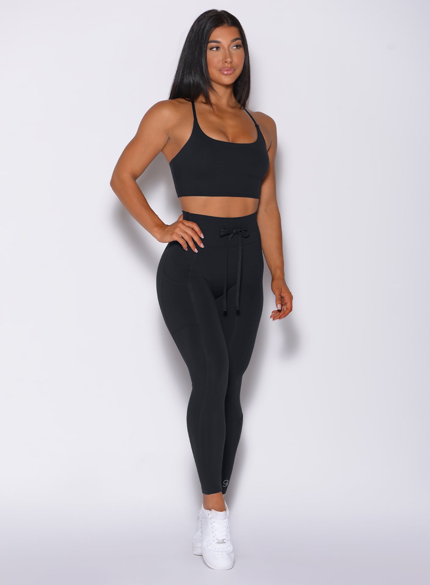 Front profile view of a model in our black empower leggings and a matching bra