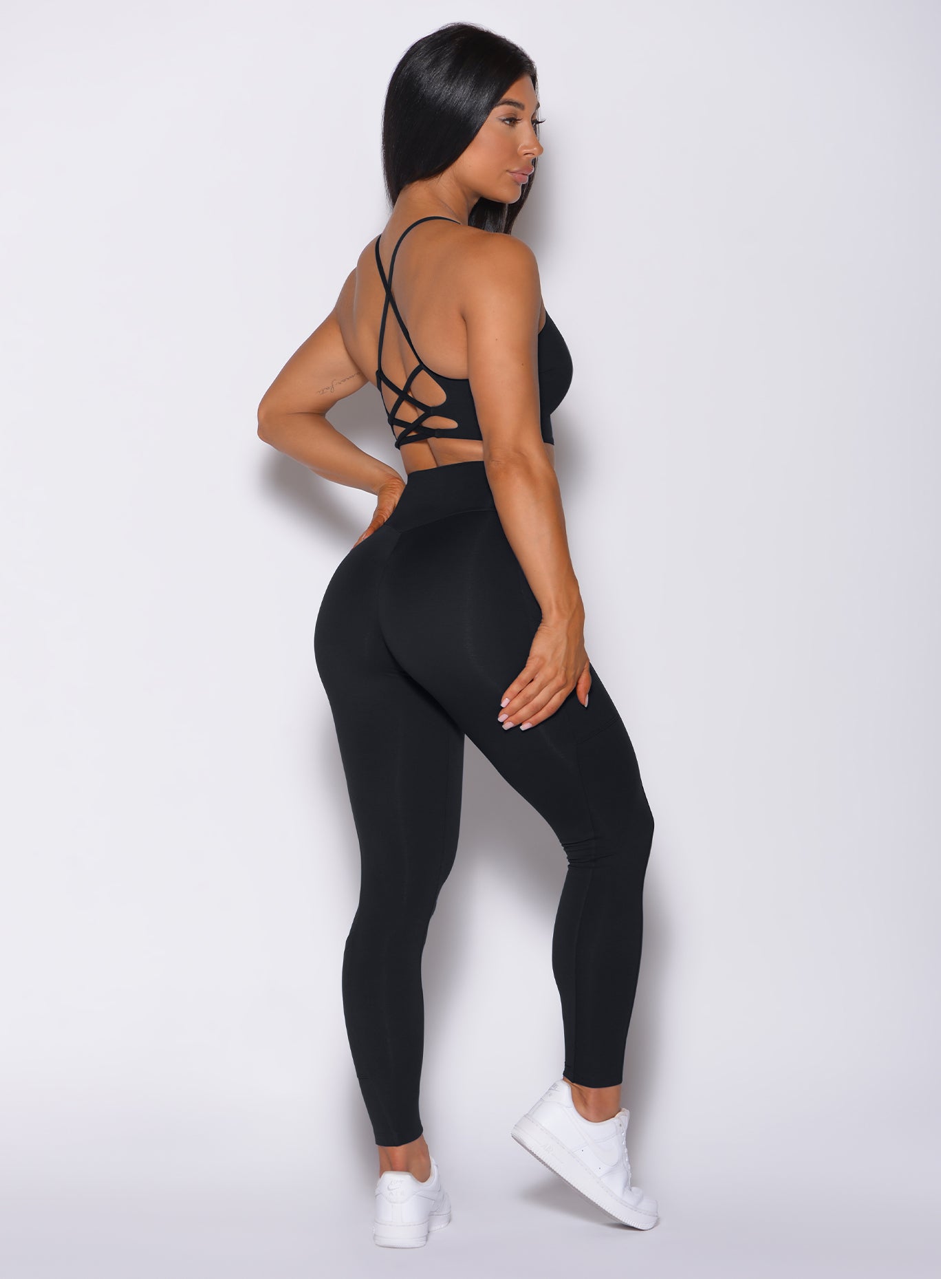Right side profile view of a model wearing our black empower leggings and a matching bra